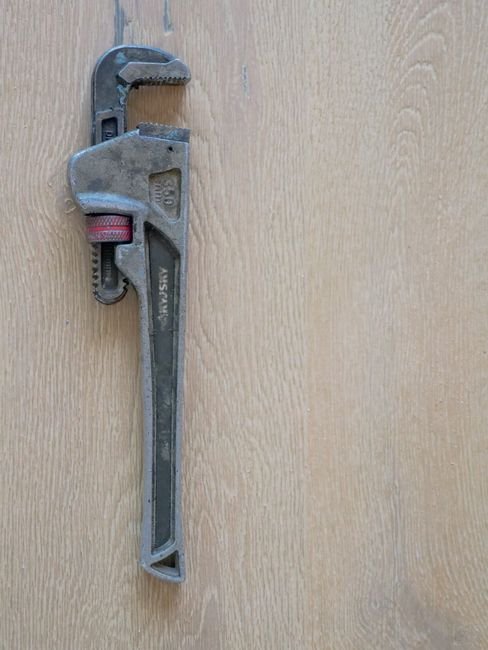 Pipe wrench on a wooden workbench